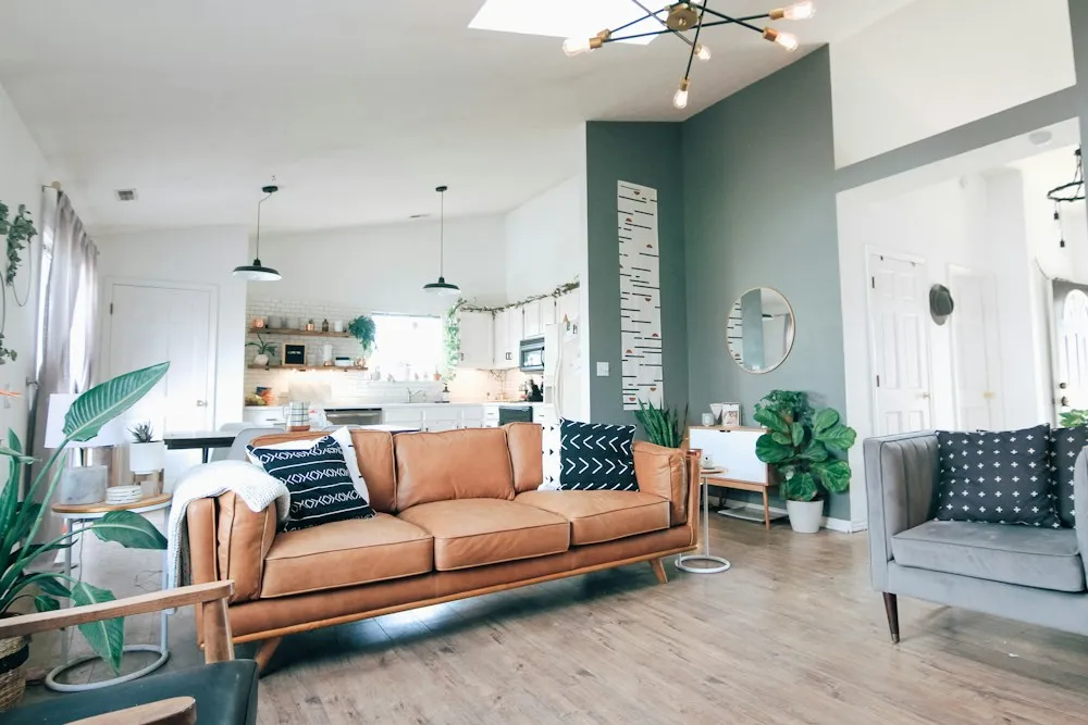 Open-plan kitchen and living area with teal cabinetry and warm timber, illustrating real renovation costs.