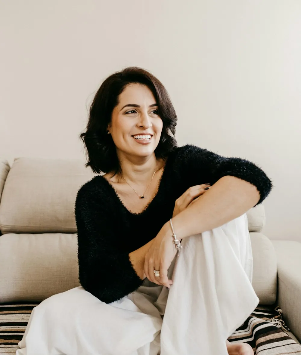 Jane Halloway, interior design consultant and founder of bumfuzzledjane.com, seated on a cream sofa in her Portland studio.
