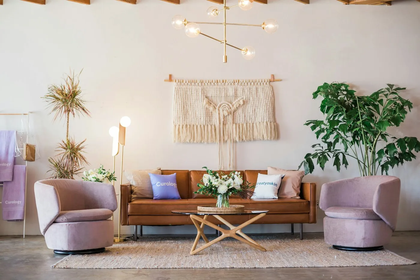 Bohemian rental living room with layered textiles, macrame wall hanging and warm timber furniture.